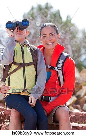 Stock Photo - Portrait of mature woman and son looking through binoculars, Sedona, Arizona, USA. Fotosearch