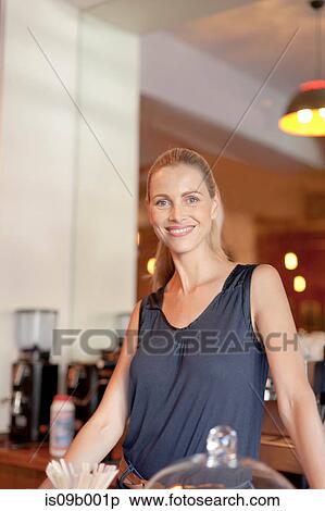 Portrait of mature woman behind counter in cafe View Large Photo Image Stock Photography - Portrait of mature woman behind counter in cafe. Fotosearch