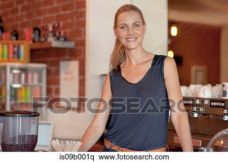 Stock Photography - Portrait of mature woman behind counter in cafe. Fotosearch