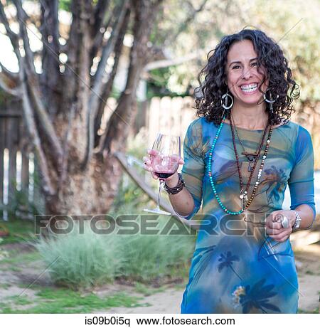 Portrait of mature woman holding red wine at garden party View Large Photo Image Stock Photography - Portrait of mature woman holding red wine at garden party. Fotosearch