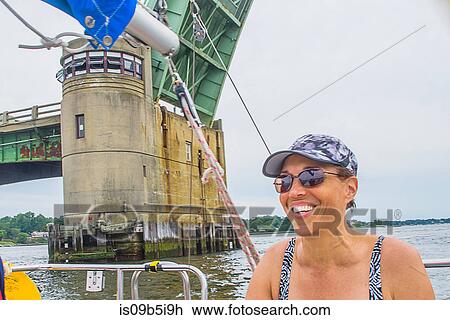 Stock Image - Portrait of mature woman on boat, smiling. Fotosearch