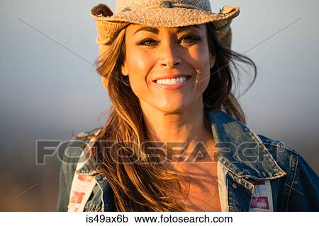 Portrait of mature woman, outdoors, wearing cowboy hat, smiling View Large Photo Image Stock Image - Portrait of mature woman, outdoors, wearing cowboy hat, smiling. Fotosearch