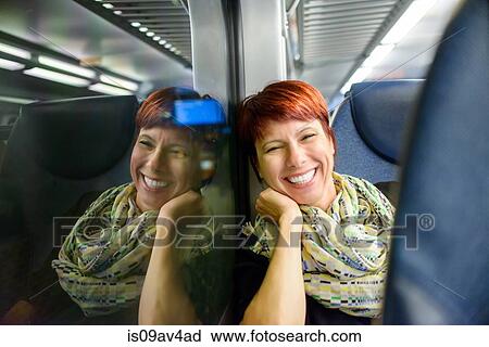 Portrait of mature woman sitting on train at night View Large Photo Image Stock Image - Portrait of mature woman sitting on train at night. Fotosearch