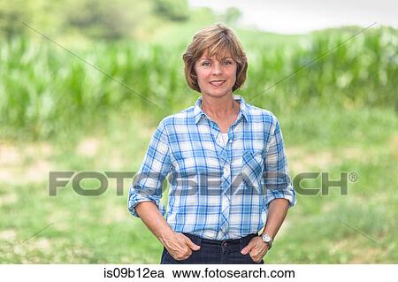 Portrait of mature woman with hands in pocket in field View Large Photo Image Stock Image - Portrait of mature woman with hands in pocket in field. Fotosearch