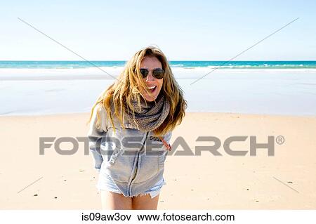 Stock Photo - Portrait of mature woman with long blond hair on beach, Conil de la Frontera, Spain. Fotosearch