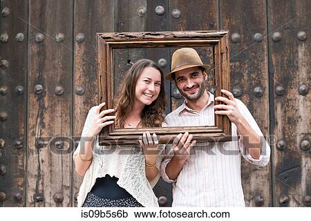 Portrait of mid adult couple, holding wooden frame in front of their faces, Mexico City, Mexico View Large Photo Image Stock Image - Portrait of mid adult couple, holding wooden frame in front of their faces, Mexico City, Mexico. Fotosearch