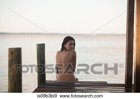 Portrait of mid adult woman in bikini looking back on pier, Santa Rosa Beach, Florida, USA View Large Photo Image Stock Photo - Portrait of mid adult woman in bikini looking back on pier, Santa Rosa Beach, Florida, USA. Fotosearch