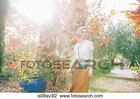 Portrait of mid adult woman, outdoors, wearing camera across body View Large Photo Image Stock Image - Portrait of mid adult woman, outdoors, wearing camera across body. Fotosearch
