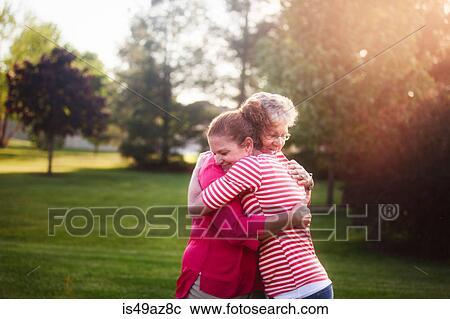 Stock Image - Portrait of mother and adult daughter, hugging. Fotosearch