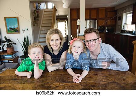 Stock Image - Portrait of parents at kitchen table with daughter and son. Fotosearch