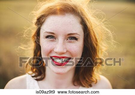 Stock Photo - Portrait of red haired woman looking at camera smiling. Fotosearch