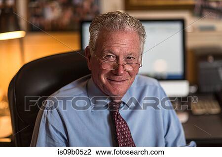 Stock Image - Portrait of senior businessman sitting on office chair. Fotosearch