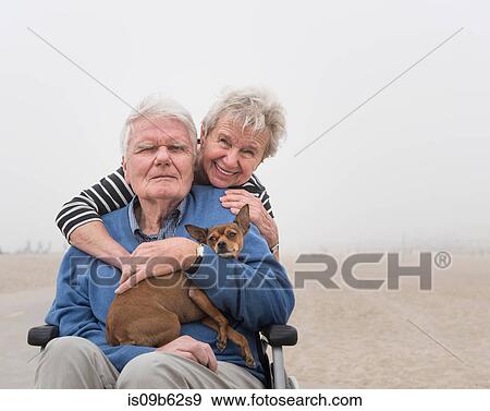 Portrait of senior man in wheelchair with wife and dog at beach, Santa Monica, California, USA View Large Photo Image Stock Photo - Portrait of senior man in wheelchair with wife and dog at beach, Santa Monica, California, USA. Fotosearch