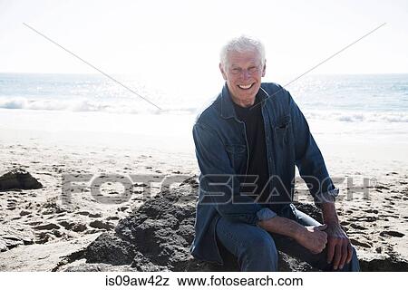 Stock Photo - Portrait of senior man on beach, smiling. Fotosearch