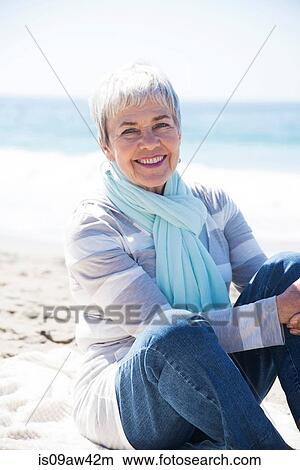 Portrait of senior woman relaxing on beach, smiling View Large Photo Image Picture - Portrait of senior woman relaxing on beach, smiling. Fotosearch
