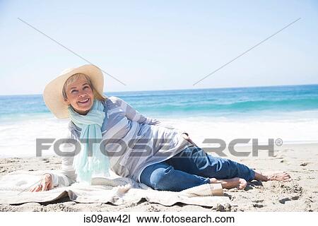 Portrait of senior woman relaxing on beach, smiling View Large Photo Image Stock Image - Portrait of senior woman relaxing on beach, smiling. Fotosearch