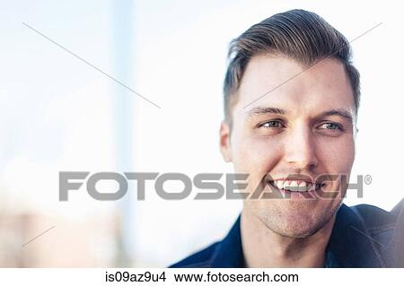 Portrait of smiling young man looking away View Large Photo Image Picture - Portrait of smiling young man looking away. Fotosearch