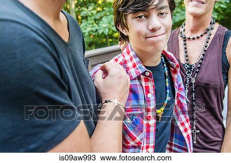 Stock Image - Portrait of teenage boy between parents. Fotosearch