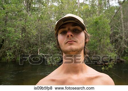 Portrait of teenage boy wearing baseball cap looking at camera View Large Photo Image Stock Photo - Portrait of teenage boy wearing baseball cap looking at camera. Fotosearch