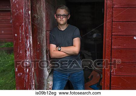 Portrait of teenage boy wearing tinted eyeglasses leaning against shed doorway View Large Photo Image Stock Image - Portrait of teenage boy wearing tinted eyeglasses leaning against shed doorway. Fotosearch