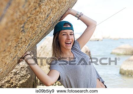 Portrait of teenage girl on rocks by sea looking at camera smiling View Large Photo Image Stock Photo - Portrait of teenage girl on rocks by sea looking at camera smiling. Fotosearch