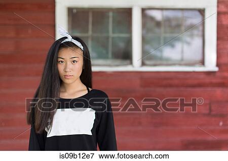 Stock Photo - Portrait of teenage girl with long black hair and hair ribbon in porch. Fotosearch