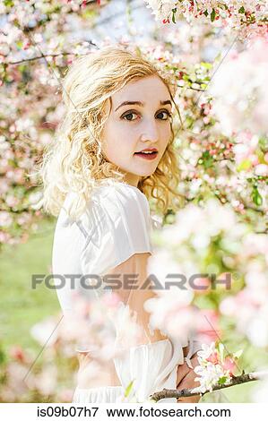 Portrait of woman by cherry blossom tree looking at camera View Large Photo Image Stock Photo - Portrait of woman by cherry blossom tree looking at camera. Fotosearch