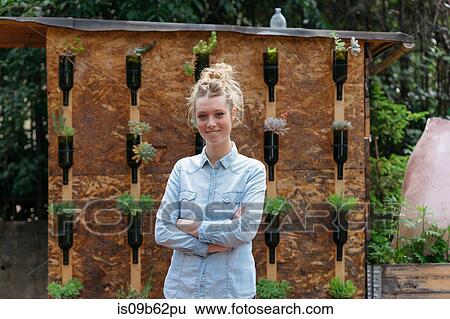 Portrait of woman in garden, arms crossed looking at camera smiling View Large Photo Image Stock Photograph - Portrait of woman in garden, arms crossed looking at camera smiling. Fotosearch