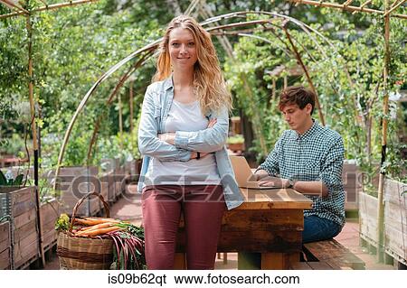 Portrait of woman in garden, arms crossed looking at camera smiling View Large Photo Image Stock Photograph - Portrait of woman in garden, arms crossed looking at camera smiling. Fotosearch