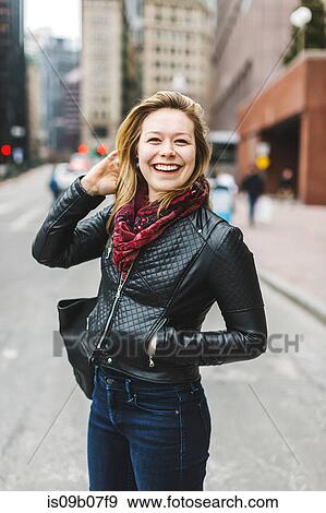 Stock Photo - Portrait of woman in urban area looking at camera smiling, Boston, Massachusetts, USA. Fotosearch