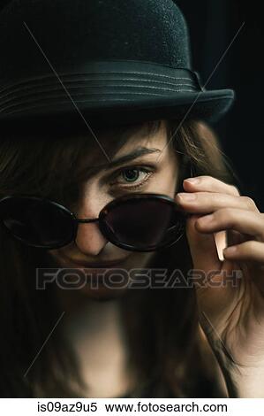 Portrait of woman looking over sunglasses at camera View Large Photo Image Stock Photography - Portrait of woman looking over sunglasses at camera. Fotosearch