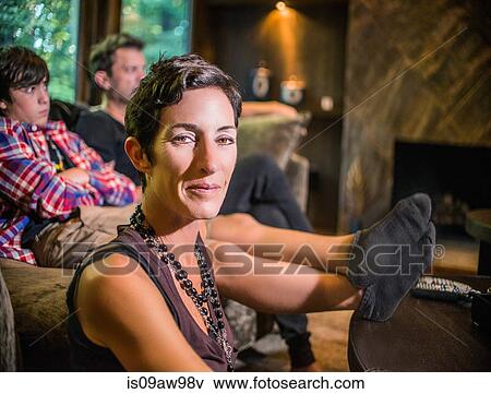 Portrait of woman sitting in front of her son and husband in living room View Large Photo Image Stock Photo - Portrait of woman sitting in front of her son and husband in living room. Fotosearch