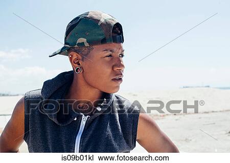 Portrait of woman wearing basketball cap looking away View Large Photo Image Stock Image - Portrait of woman wearing basketball cap looking away. Fotosearch