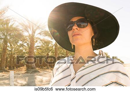 Portrait of woman wearing sunglasses and sunhat looking away, Palm Springs, California, USA View Large Photo Image Stock Photograph - Portrait of woman wearing sunglasses and sunhat looking away, Palm Springs, California, USA. Fotosearch