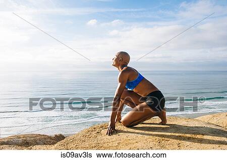 Portrait of young crouching on rocks beside sea, sun falling on face View Large Photo Image Stock Photograph - Portrait of young crouching on rocks beside sea, sun falling on face. Fotosearch