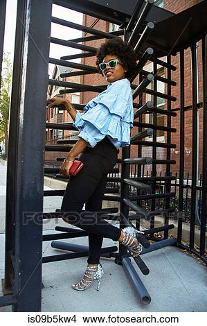 Portrait of young female fashion blogger by rotating gate, New York, USA View Large Photo Image Picture - Portrait of young female fashion blogger by rotating gate, New York, USA. Fotosearch