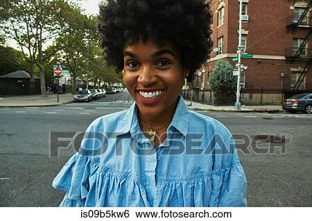 Portrait of young female fashion blogger with afro hair on urban street, New York, USA View Large Photo Image Stock Photograph - Portrait of young female fashion blogger with afro hair on urban street, New York, USA. Fotosearch