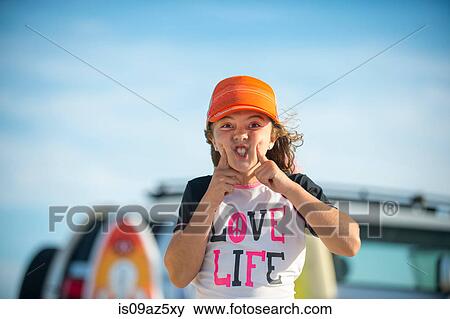 Stock Photo - Portrait of young girl at beach, pulling funny face. Fotosearch