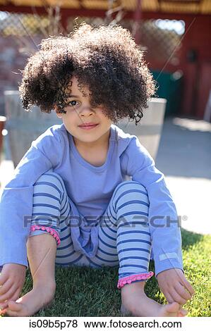 Portrait of young girl sitting on grass View Large Photo Image Stock Photo - Portrait of young girl sitting on grass. Fotosearch