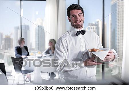 Stock Image - Portrait of young male waiter in hotel restaurant. Fotosearch