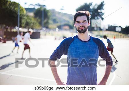 Stock Image - Portrait of young man on basketball court. Fotosearch