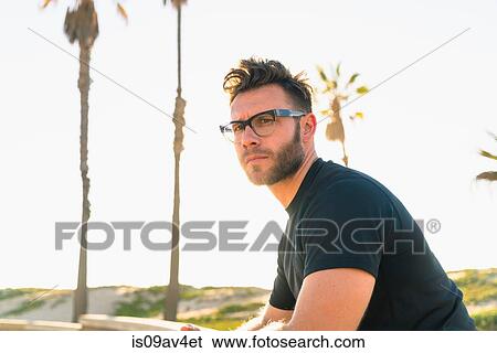 Portrait of young man, stern expression, outdoors View Large Photo Image Stock Photograph - Portrait of young man, stern expression, outdoors. Fotosearch