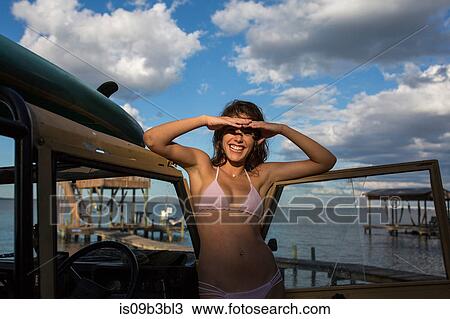 Portrait of young woman in bikini shielding eyes on pier, Santa Rosa Beach, Florida, USA View Large Photo Image Stock Image - Portrait of young woman in bikini shielding eyes on pier, Santa Rosa Beach, Florida, USA. Fotosearch