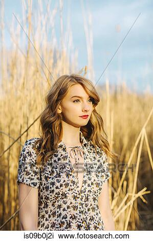 Portrait of young woman in wheat field, looking away View Large Photo Image Stock Image - Portrait of young woman in wheat field, looking away. Fotosearch