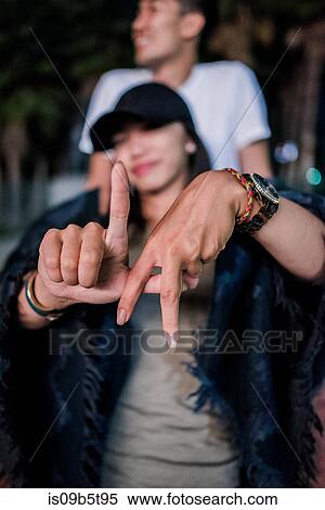 Portrait of young woman making LA hand gesture outside Los Angeles County Museum of Art at night View Large Photo Image Stock Photography - Portrait of young woman making LA hand gesture outside Los Angeles County Museum of Art at night. Fotosearch