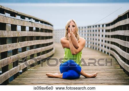 Portrait of young woman practicing yoga pose on wooden pier View Large Photo Image Stock Image - Portrait of young woman practicing yoga pose on wooden pier. Fotosearch