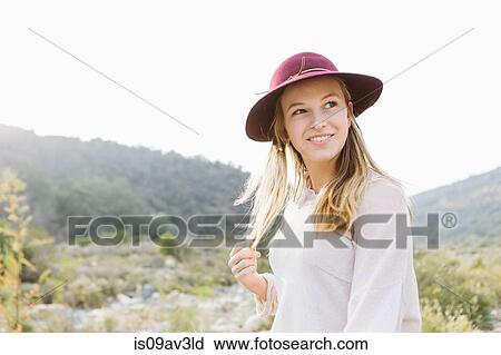 Portrait of young woman, smiling, outdoors View Large Photo Image Stock Image - Portrait of young woman, smiling, outdoors. Fotosearch