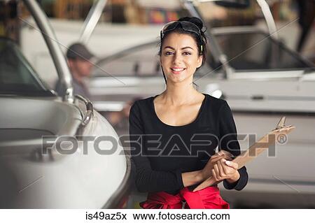 Portrait of young woman with clipboard in boat repair workshop View Large Photo Image Stock Photo - Portrait of young woman with clipboard in boat repair workshop. Fotosearch