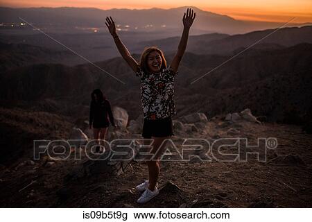 Portrait of young woman with hands raised in Joshua Tree National Park at sunset, California, USA View Large Photo Image Stock Image - Portrait of young woman with hands raised in Joshua Tree National Park at sunset, California, USA. Fotosearch