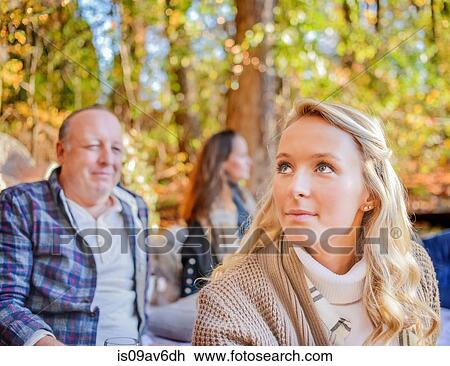 Stock Image - Portrait of young woman with parents in woods. Fotosearch